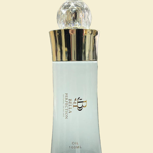Bella Perfection oil bottle with gold cap on a desk